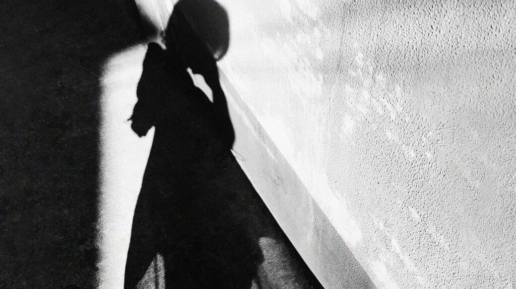 A shadow of a female against a wall.