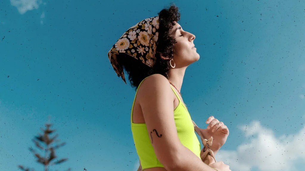 A person closing her eyes and looking relaxed.