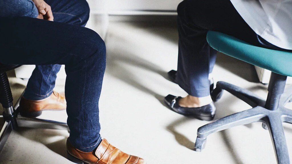 Two people's legs as they converse.