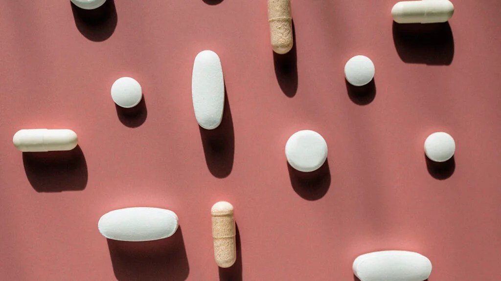 Different shaped pills against a brown background