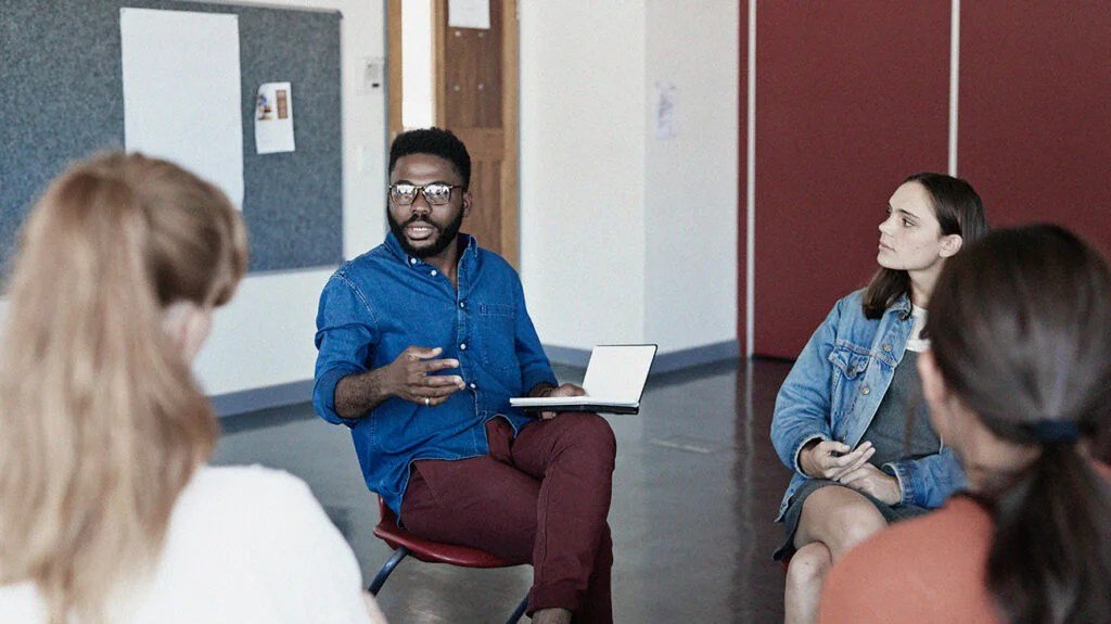 gettyimages-1171159795_header-1024x575-1 A mental health professional is talking to a group of people who