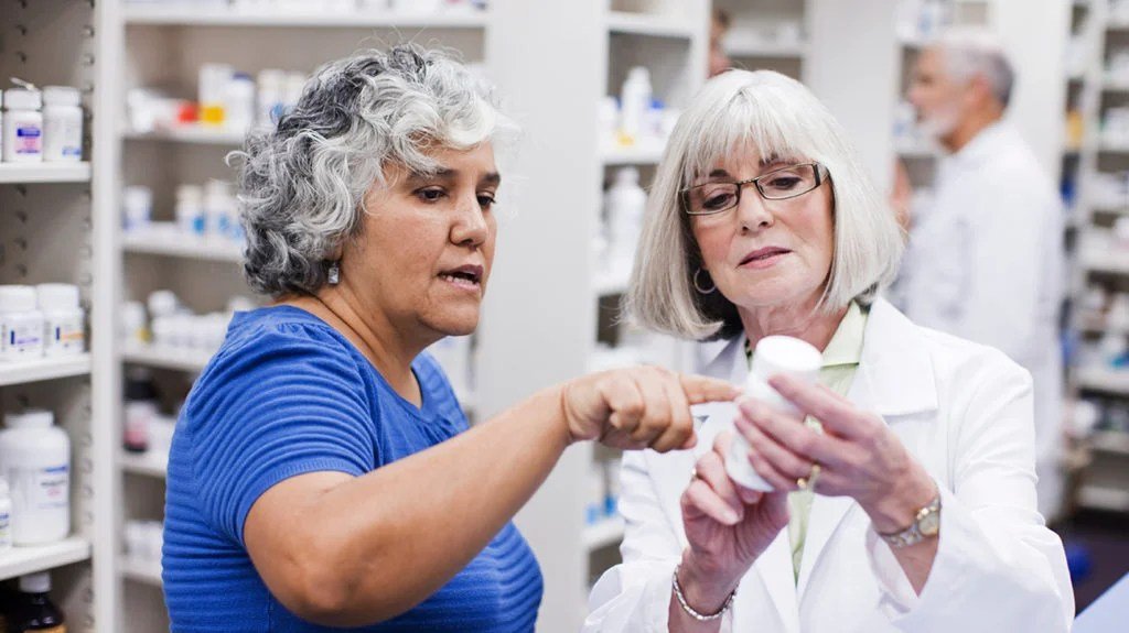 a senior woman talking to a pharmacist about a certain drug that she has cover for with her healthspring medicare plan