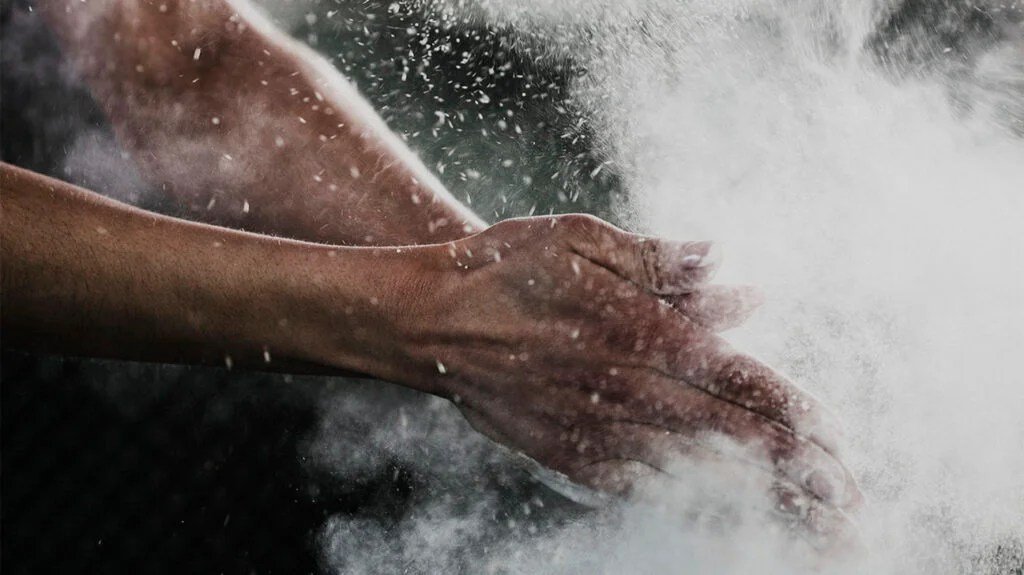 An image of a person using hand dusting chalk powder for exercising.