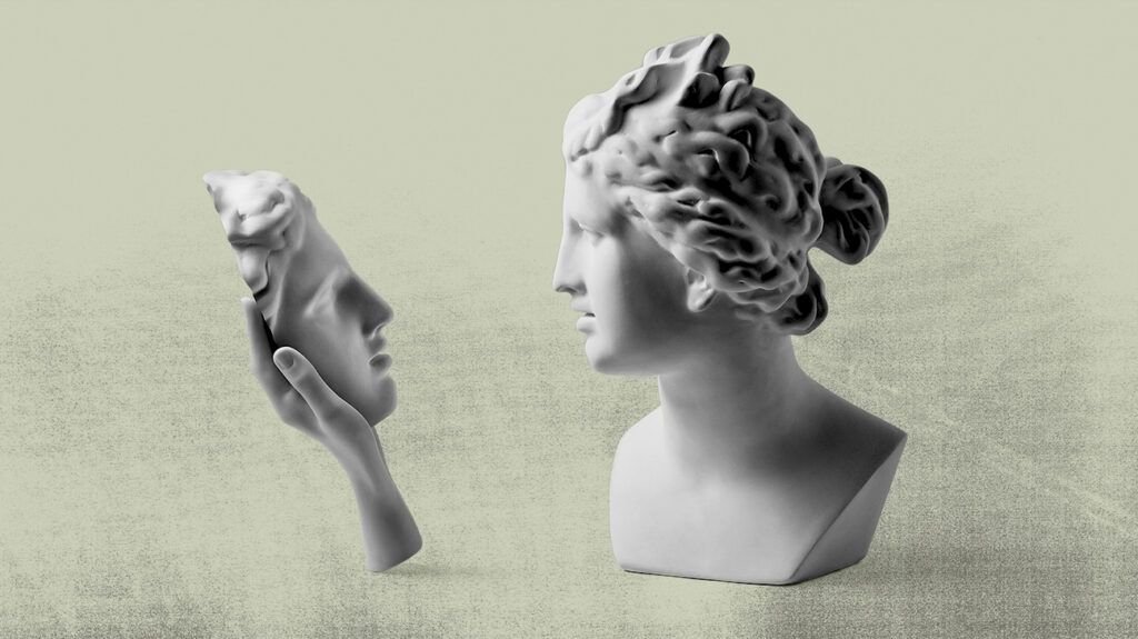 A statue of a female looking at a reflection of her face